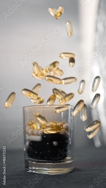 Fototapeta Vitamins and dietary supplements close-up. Macrophoto of capsules. Vitamins on the table.