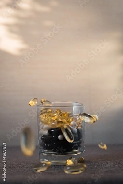 Fototapeta Vitamins and dietary supplements close-up. Macrophoto of capsules. Vitamins on the table.