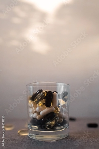 Fototapeta Vitamins and dietary supplements close-up. Macrophoto of capsules. Vitamins on the table.