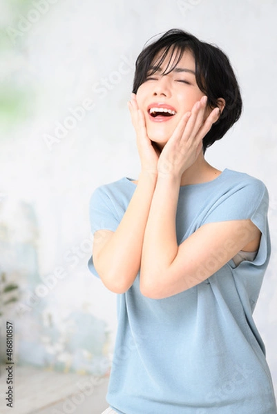 Fototapeta 美容に使いやすい顔に手を添える美しい日本人女性　縦　コピースペースと前ボケあり