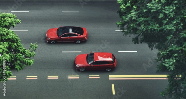 Fototapeta top view Two red cars cruising on a city street with trees.