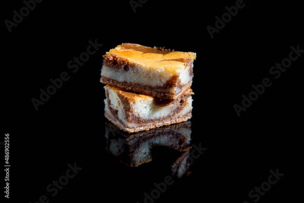 Fototapeta Besquit, cake on a black background, dark and light layer of besquit on a black background, reflection, copy space