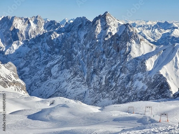 Fototapeta Panorama of ski resort in the german alps. Skiers on a slope on a sunny winter day.