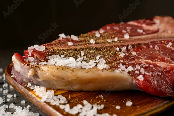 Fototapeta Raw T-bone steak cooking on stone table