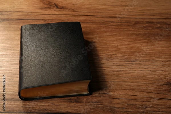 Obraz Bible with black cover on wooden table. Space for text