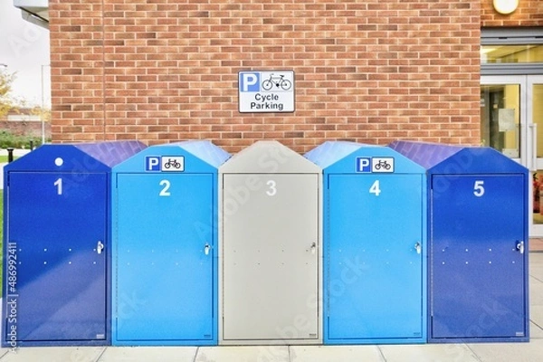 Fototapeta Row of Bicycle Lockers in front of a Brick Wall in a City Centre.