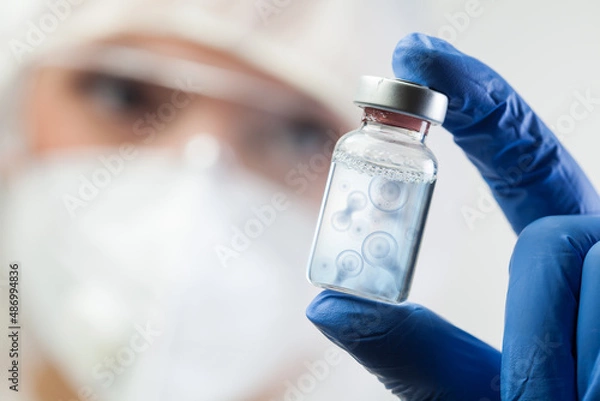 Fototapeta Cell division process conceptual illustration,lab scientist holding ampoule vial with DNA cell nucleus molecules splitting
