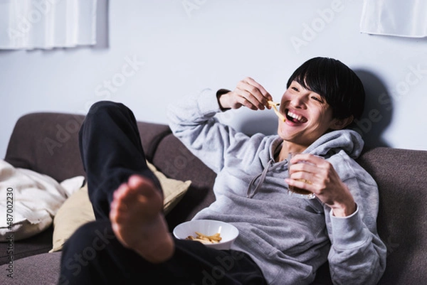 Fototapeta フライドポテトを食べながら映画を楽しむ男性