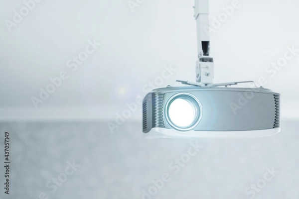 Fototapeta A working multimedia video projector for home theater or presentations on a ceiling mount.