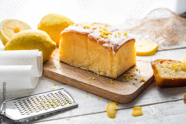 Fototapeta Several slices of lemon cake, lemon sponge cake, homemade, with sugar, flour, honey, yeast and lemons, dessert or for breakfast, on a wooden background.