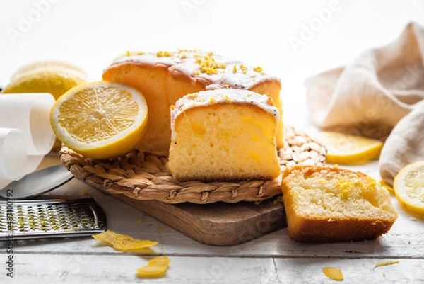Fototapeta Several slices of lemon cake, lemon sponge cake, homemade, with sugar, flour, honey, yeast and lemons, dessert or for breakfast, on a wooden background.