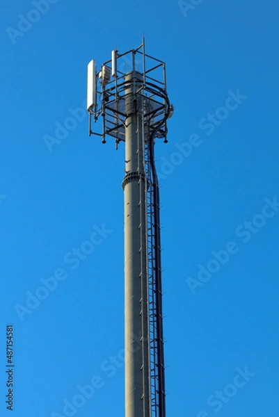 Fototapeta Telecommunication tower of 4G and 5G cellular. Macro Base Station. 5G radio network telecommunication equipment with radio modules and smart antennas mounted on a metal. Blue sky in the background.