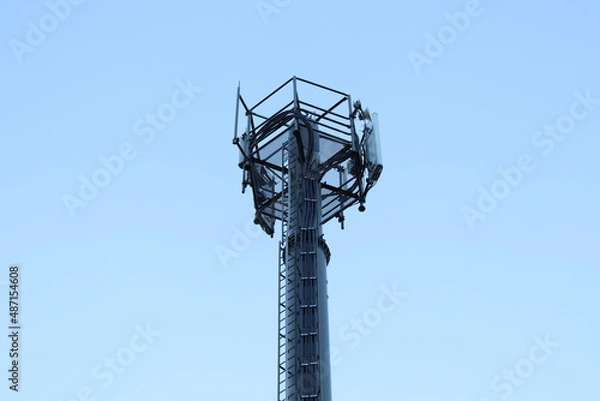 Fototapeta Telecommunication tower of 4G and 5G cellular. Macro Base Station. 5G radio network telecommunication equipment with radio modules and smart antennas mounted on a metal. Blue sky in the background.