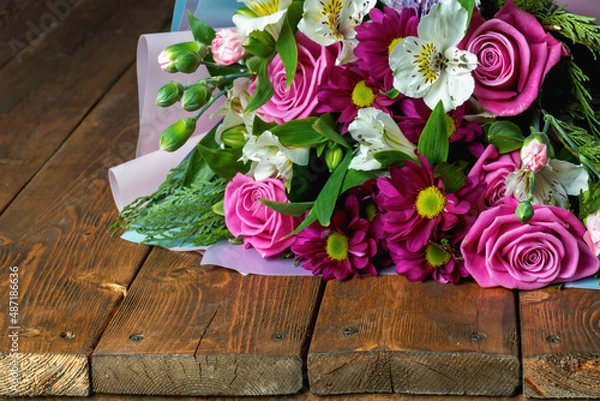 Fototapeta A fresh bouquet of flowers lies on a wooden background. space for copying.