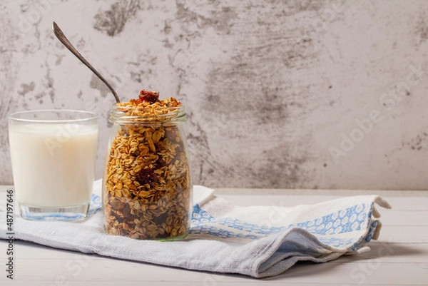 Fototapeta Granola bowl with raisins, nuts and fresh berries. Homemade crunchy granola on grey concrete background, top view