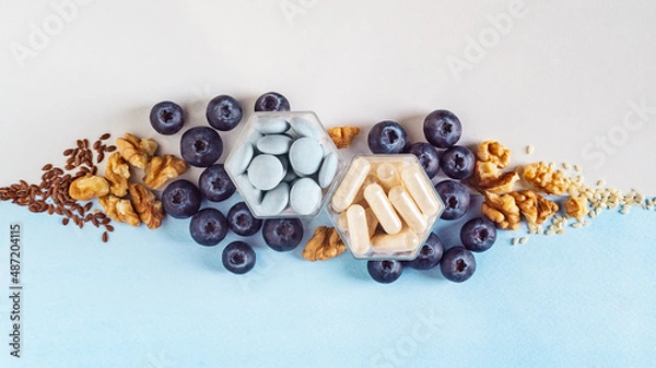 Fototapeta Various capsules with dietary supplements or vitamines and fresh blueberry and nuts