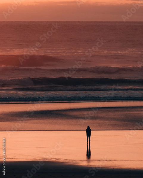 Obraz Silhouette of a person standing at the beach at sunset