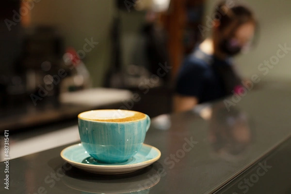 Obraz A cup of beautiful ceramic with coffee or cappuccino stands on the bar counter on the table