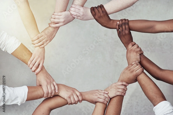 Fototapeta We are more powerful together. Shot of a group of hands holding on to each other.