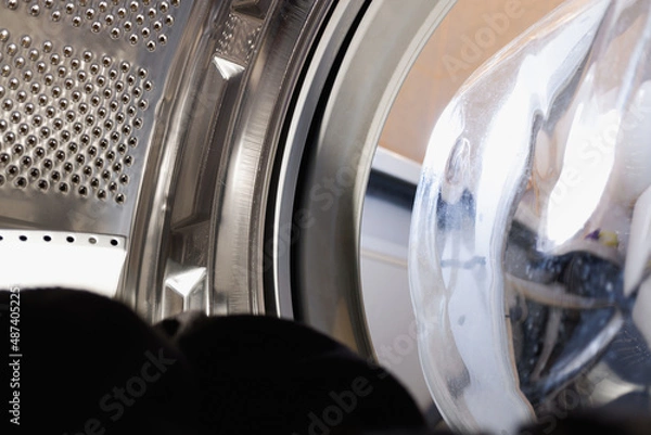 Obraz view from washing machine with black clothes