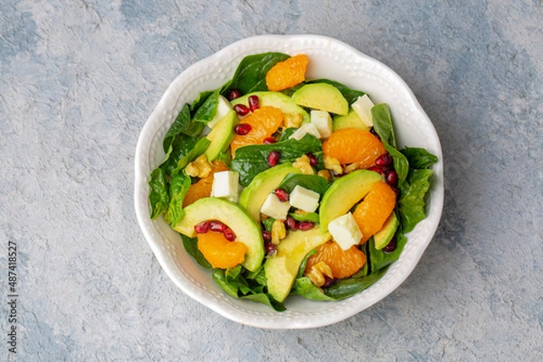 Obraz Close up view of spinach, avocado salad with orange, pomegranate and walnut