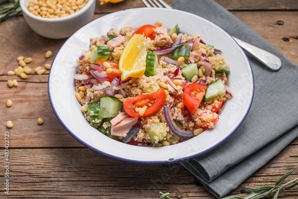 Obraz Food dieting concept, tuna salad. Couscous salad with conserved tuna, tomatoes, cucumbers and purple onions on table. Copy space.