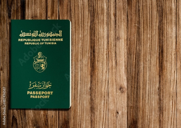 Fototapeta Tunisian passport on wooden background ,the Tunisian passport is issued to citizens of Tunisia for international travel.
