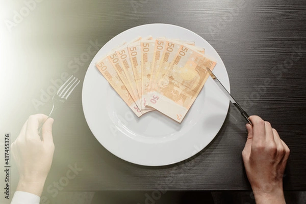 Obraz Money on a plate with a fork and knife. Euro banknotes. Wealth and the greed of cash. Business.