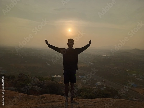 Fototapeta silhouette of man standing on top of mountain