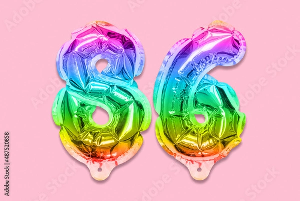 Fototapeta Rainbow foil balloon number, digit eighty six on a pink background. Birthday greeting card with inscription 86. Top view. Numerical digit. Celebration event, template.