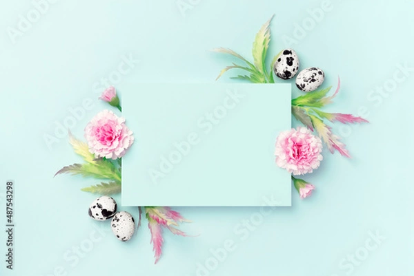 Fototapeta Easter composition. Easter eggs, flowers, paper blank on pastel blue background. Flat lay, top view, copy space.