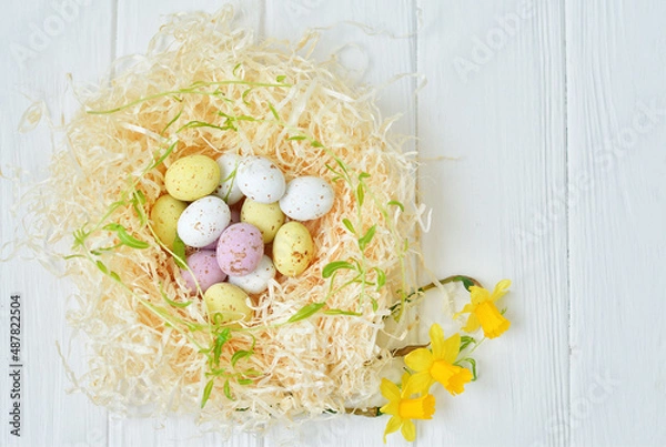 Obraz Easter eggs in nest on light wooden background.Happy Easter. Spring mood