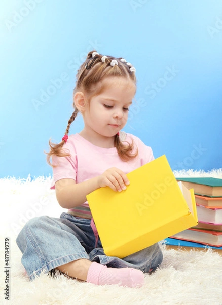 Fototapeta cute little girl with colorful books, on blue background