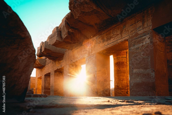 Fototapeta Aligned shot of ancient egyptian pillars in karnak temple in luxor, ancient temple open to public. Remains of the great egyptian civilization. Sun rays poking through the pillars