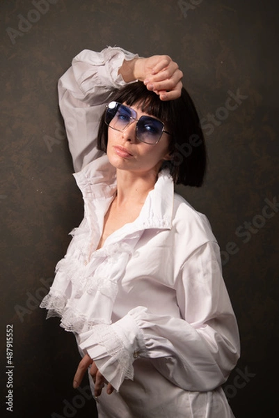 Obraz Young beautiful cheerful girl sitting on floor wearing white blouses and black jeans on the white background. Winter, fall autumn or spring minimal outfit. High quality photo