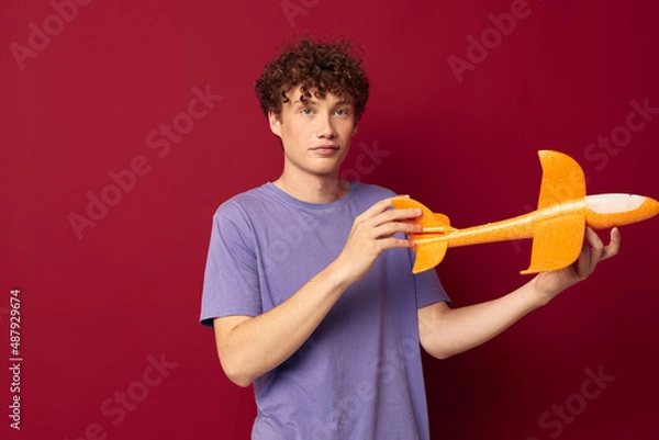 Fototapeta kinky guy with toy airplane entertainment red background unaltered