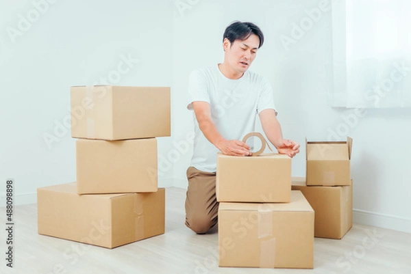 Fototapeta 荷造りする男性（困る）
