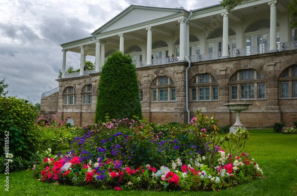 Obraz Blooming flower beds in the autumn park against the background of an ancient palace gallery