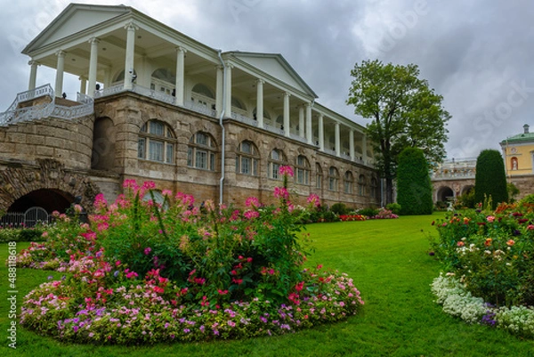 Obraz Blooming flower beds in the autumn park against the background of an ancient palace gallery