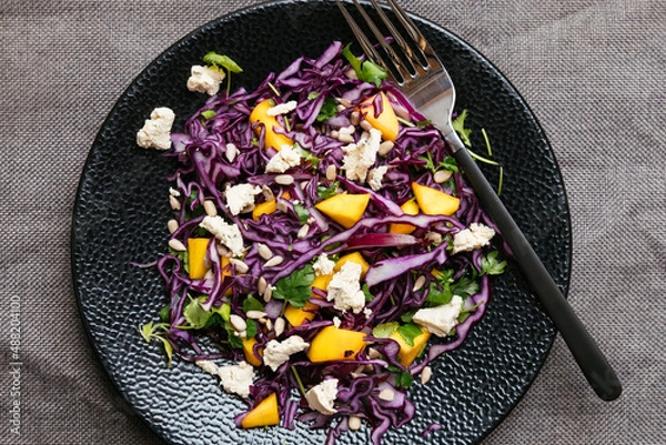 Fototapeta Home made red cabbage mango salad with vegan feta