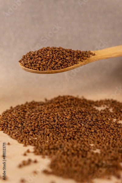 Fototapeta Buckwheat in a spoon.
Scattered buckwheat.