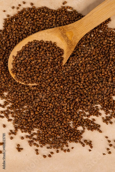 Fototapeta Buckwheat in a spoon.
Scattered buckwheat.