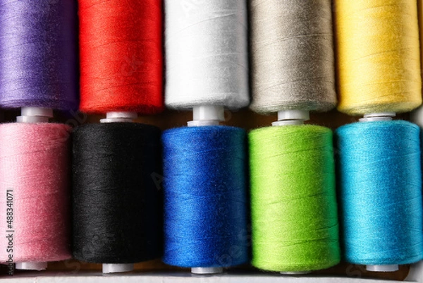 Fototapeta Spools with sewing threads as background, closeup