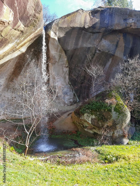 Fototapeta The beautiful waterfall springs from the rock where the legend says that a giant sleeps near the Corbii de Piatra Monastery.