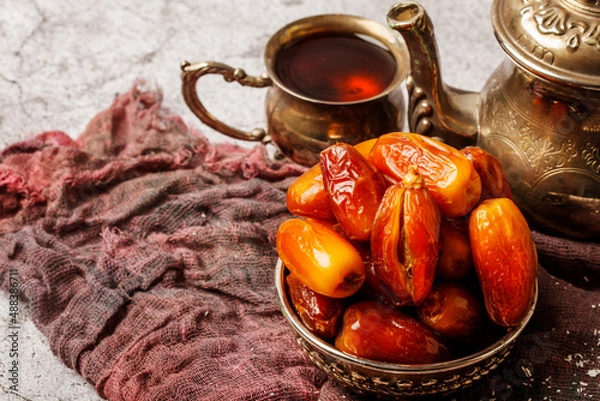 Fototapeta Traditional Turkish delight with Turkish tea on gray background. Ramadan Kareem celebration concept. Fragrant Turkish tea and Turkish sweets in national dishes.