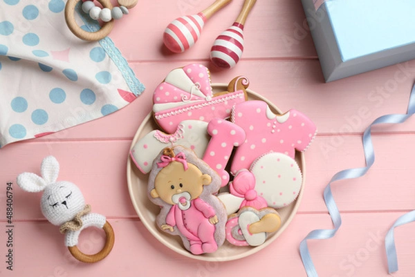 Fototapeta Tasty cookies of different shapes and toys on pink wooden table, flat lay. Baby shower party