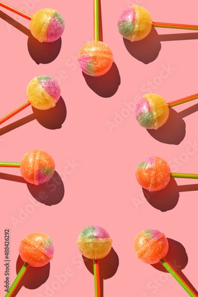 Fototapeta Colorful Set of Lollipops. pattern made with caramel on a stick on bright pink background.  creative pattern.  lot of lollipops chupa chups...