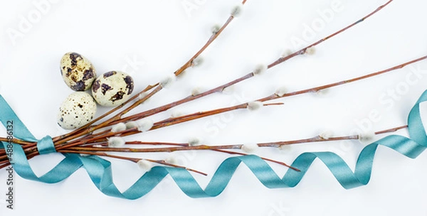 Fototapeta A bouquet of fluffy willow branches, Easter eggs and figures of hares on a light background. Happy Easter, Palm Sunday. Easter composition in the style of minimalism. Easter card.