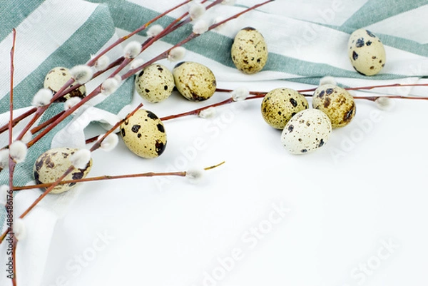 Fototapeta A bouquet of fluffy willow branches, Easter eggs and figures of hares on a light background. Happy Easter, Palm Sunday. Easter composition in the style of minimalism. Easter card.