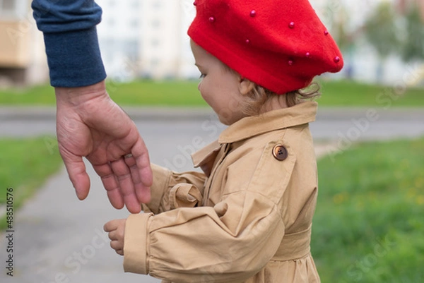 Obraz The concept of protection against child abduction. The kid stands next to a man who holds out his hand to him.